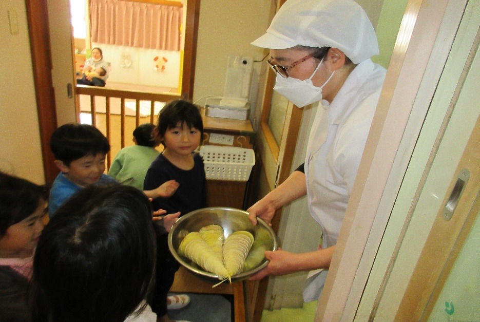 写真：給食の先生にむいたタケノコを渡して