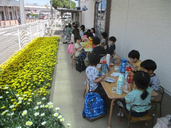 写真：保育所の花畑でお弁当